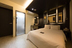 A hotel room with a bed, a nightstand, a mirror, and a door. - Achasan Station Wall Hotel (Seoul)