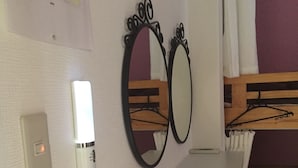 A room with bunk beds, a whiteboard, a red stool, and two wall-mounted mirrors. - Guest House Naraya - Hostel (Fukuoka)