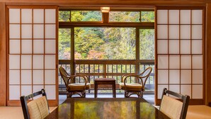 Una habitación tradicional japonesa con suelo de tatami, una mesa baja y dos sillas.