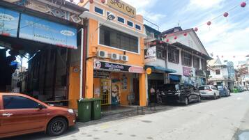 Una calle con diversas tiendas, incluyendo un hotel y servicios de alojamiento para mochileros.