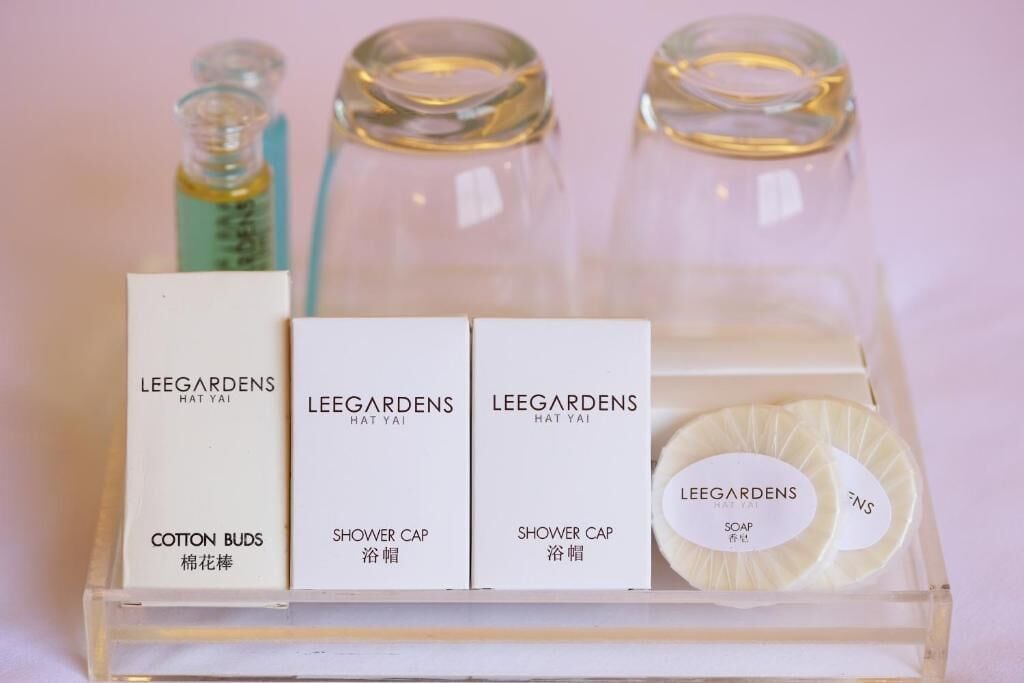 A set of toiletries in a clear plastic tray, including cotton buds, a shower cap, and soap.