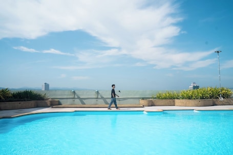 Una piscina al aire libre, sillones reclinables de piscina