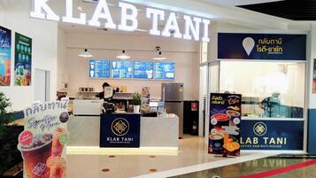 A coffee shop named KLAB TANI with a visible counter, menu boards, and a signboard advertising signature menu items.