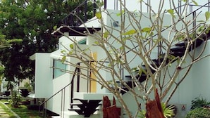 A modern building with a staircase and a tree in the foreground. - Cha-am Eco Camp (Cha-am)