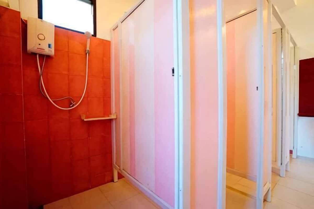 Hotelkamer met een schuifdeur, een douchegedeelte en uitzicht op de gang.