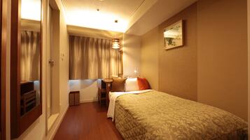 A hotel room with a bed, a desk, and a chair.