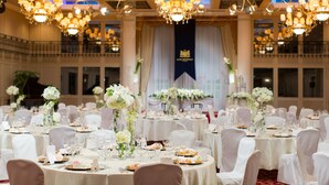 A banquet hall with round tables, white tablecloths, and chandeliers. - Hotel Monarque Tottori (Tottori)