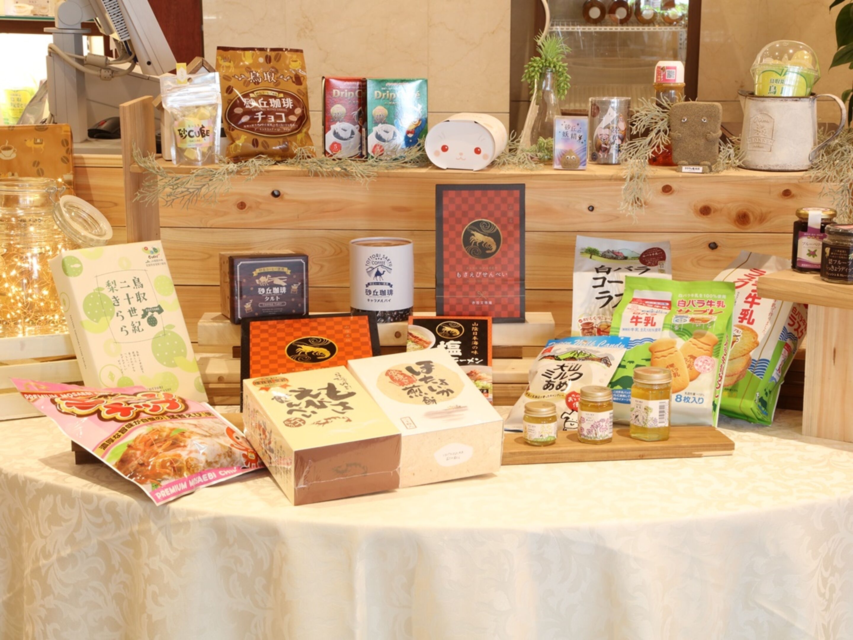 A display of various packaged food items and beverages on a wooden table.