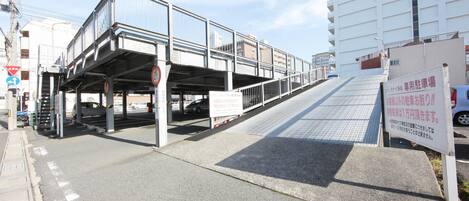 A pedestrian bridge with a signboard and a building in the background.