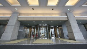 A modern hotel entrance with a revolving door, recessed lighting, and a clean, geometric design. - Hotel Monarque Tottori (Tottori)