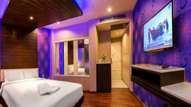 A modern hotel room with a bed, a TV, and a desk. - The Ring Hotel (Hat Yai)