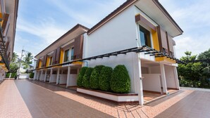 A modern two-story residential building with a covered patio area and a well-maintained garden. - The Ring Hotel (Hat Yai)