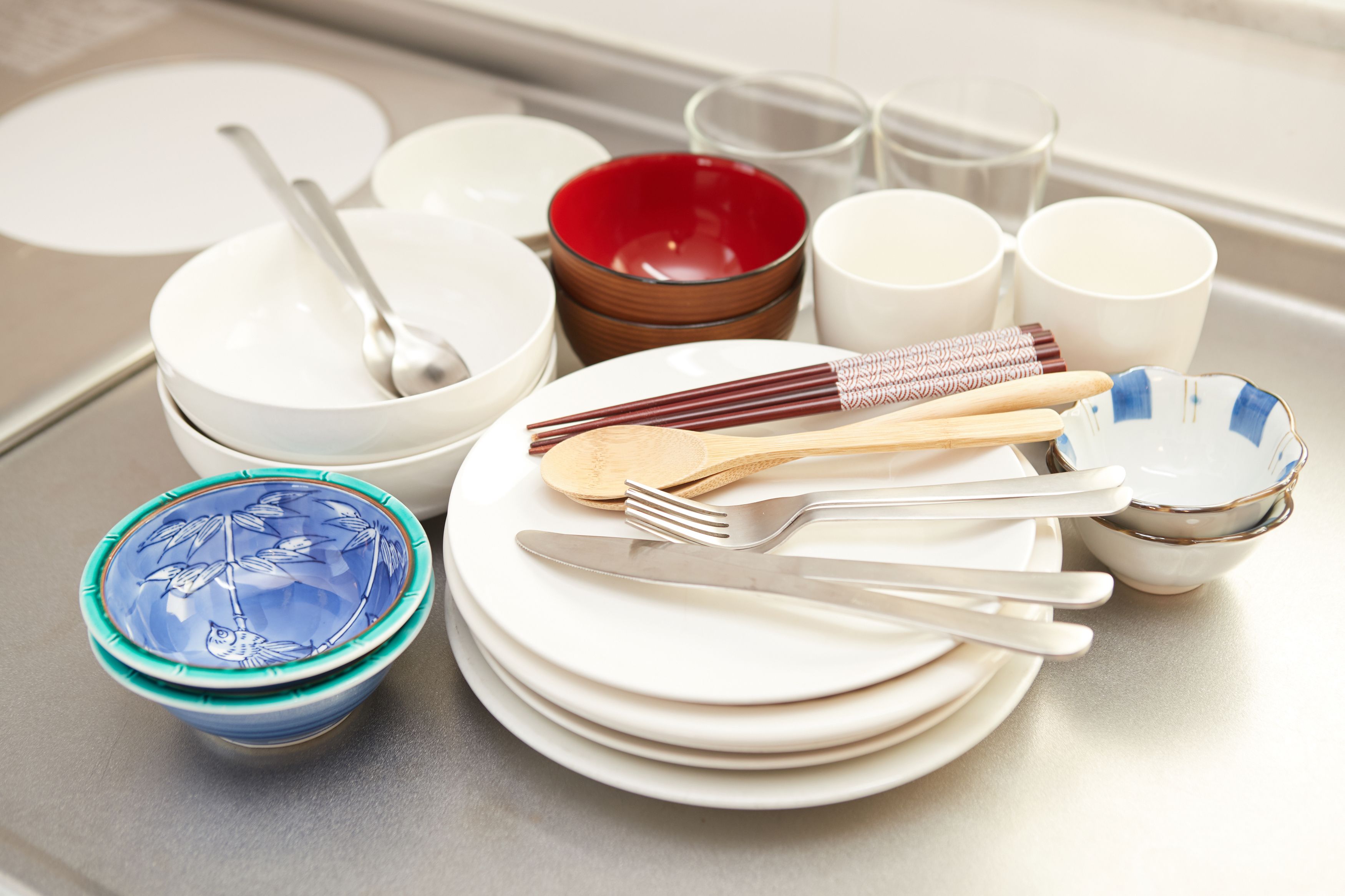 Un plan de travail de cuisine avec différents plats, ustensiles et un saladier.