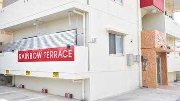 A building with a sign reading "RAINBOW TERRACE" and a caution sign.