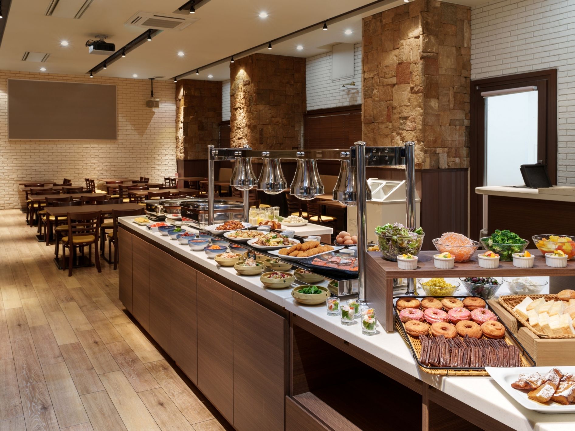 A buffet setup with various food items and a seating area with tables and chairs.