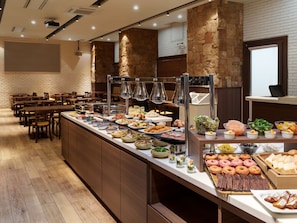 A buffet setup with various food items and a seating area with tables and chairs. - Premier Hotel Cabin Sapporo (Sapporo)