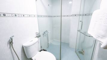 A bathroom with a glass-enclosed shower, a toilet, and a towel rack.
