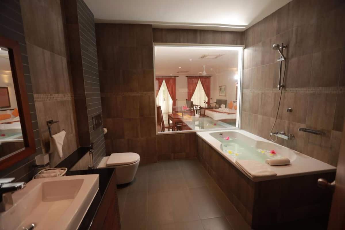 Ein modernes Badezimmer mit einer großzügigen Badewanne, einer separaten Duschkabine und einer Glaskabine für die Dusche.