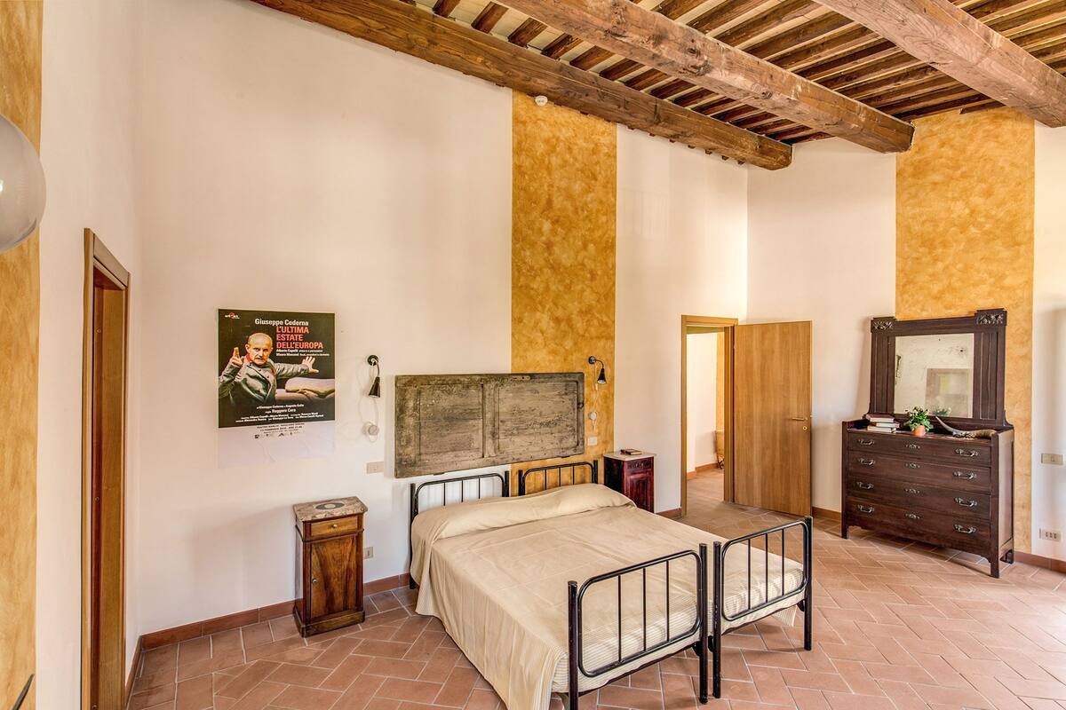 Une chambre à coucher avec un lit, une armoire en bois et une affiche accrochée au mur.