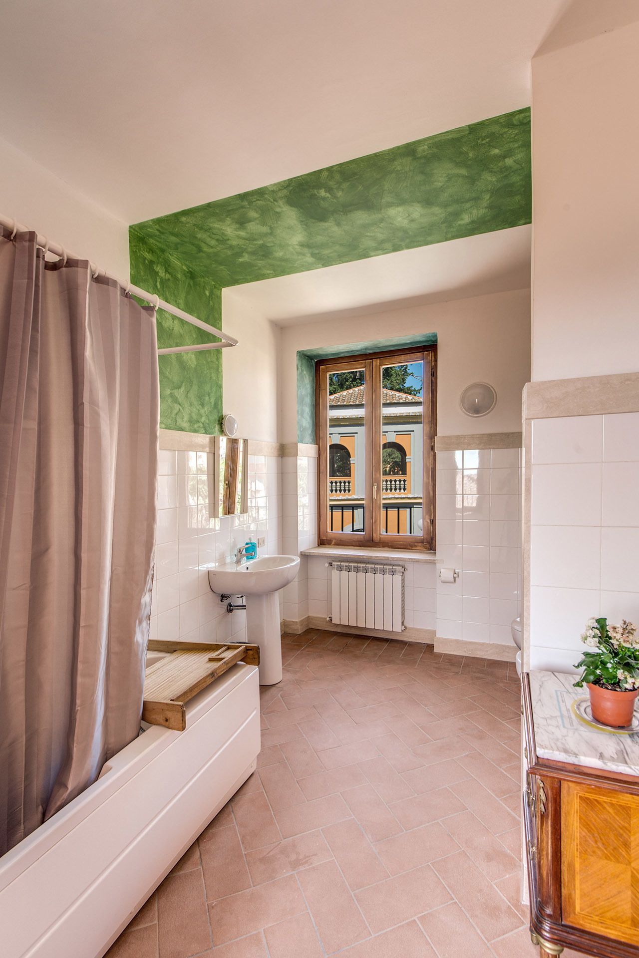 Un baño con ducha, lavamanos y ventana.