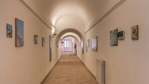 Un couloir aux murs ornés d’œuvres d’art, doté d’un sol carrelé et d’un plafond en arc de cercle.