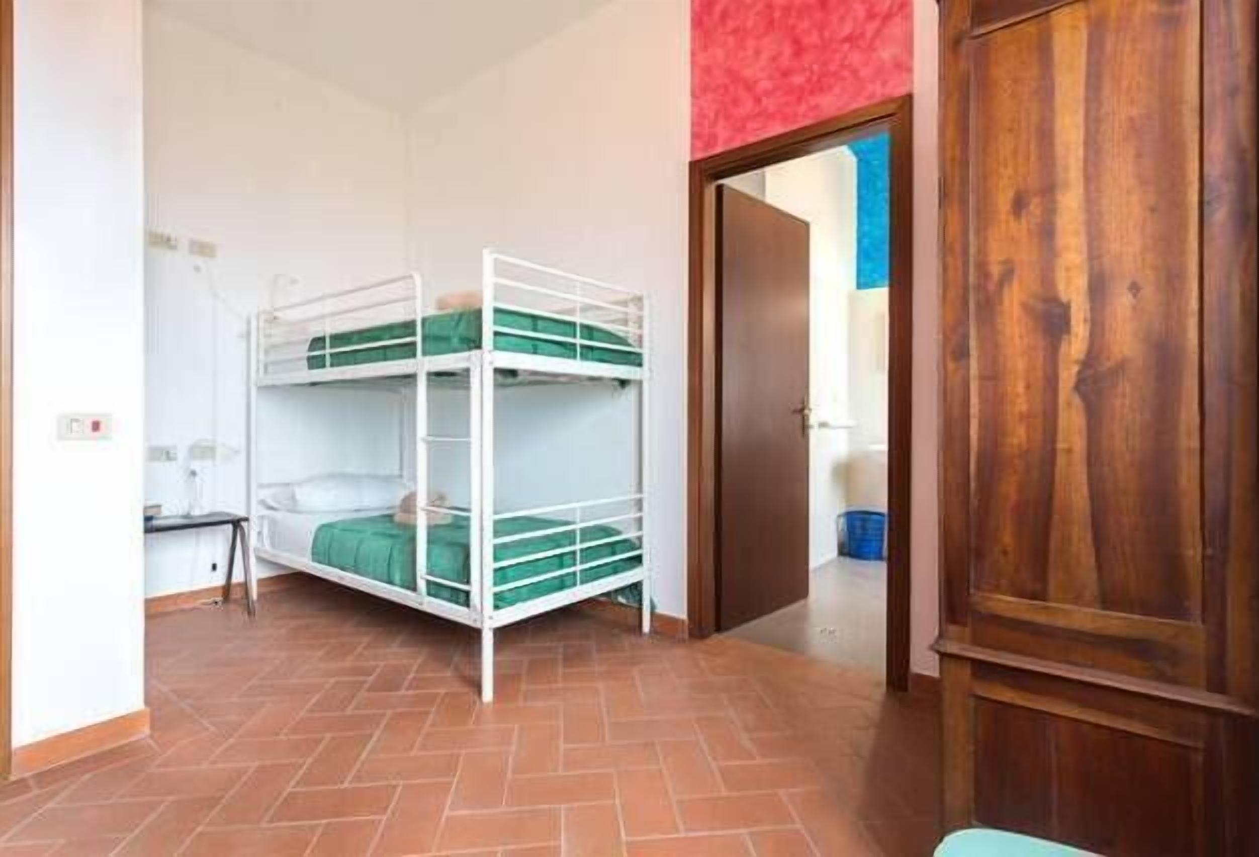 Une chambre avec un lit superposé, un bureau et une armoire.