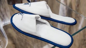 Un par de zapatillas blancas con detalles azules y un logotipo en la suela, sobre una superficie de vidrio transparente.