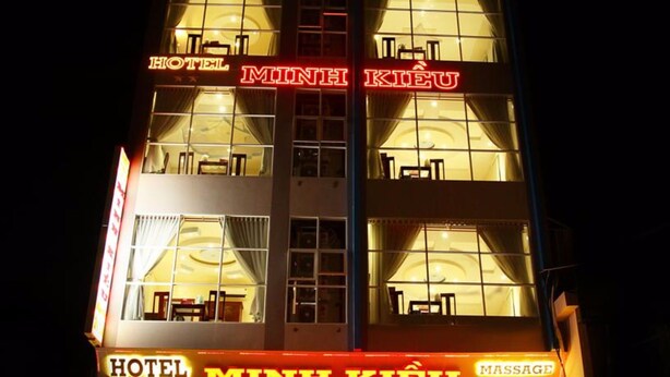 A hotel with a neon sign indicating it offers massage services. - Minh Kieu Hotel (My Tho)