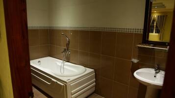 Et badeværelse med badekar, vask og spejl.