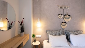 Un dormitorio moderno con cama, mesitas de noche, un espejo y decoración en la pared.