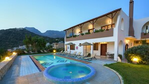 Un hotel con piscina, sillones de descanso y vistas a la montaña.