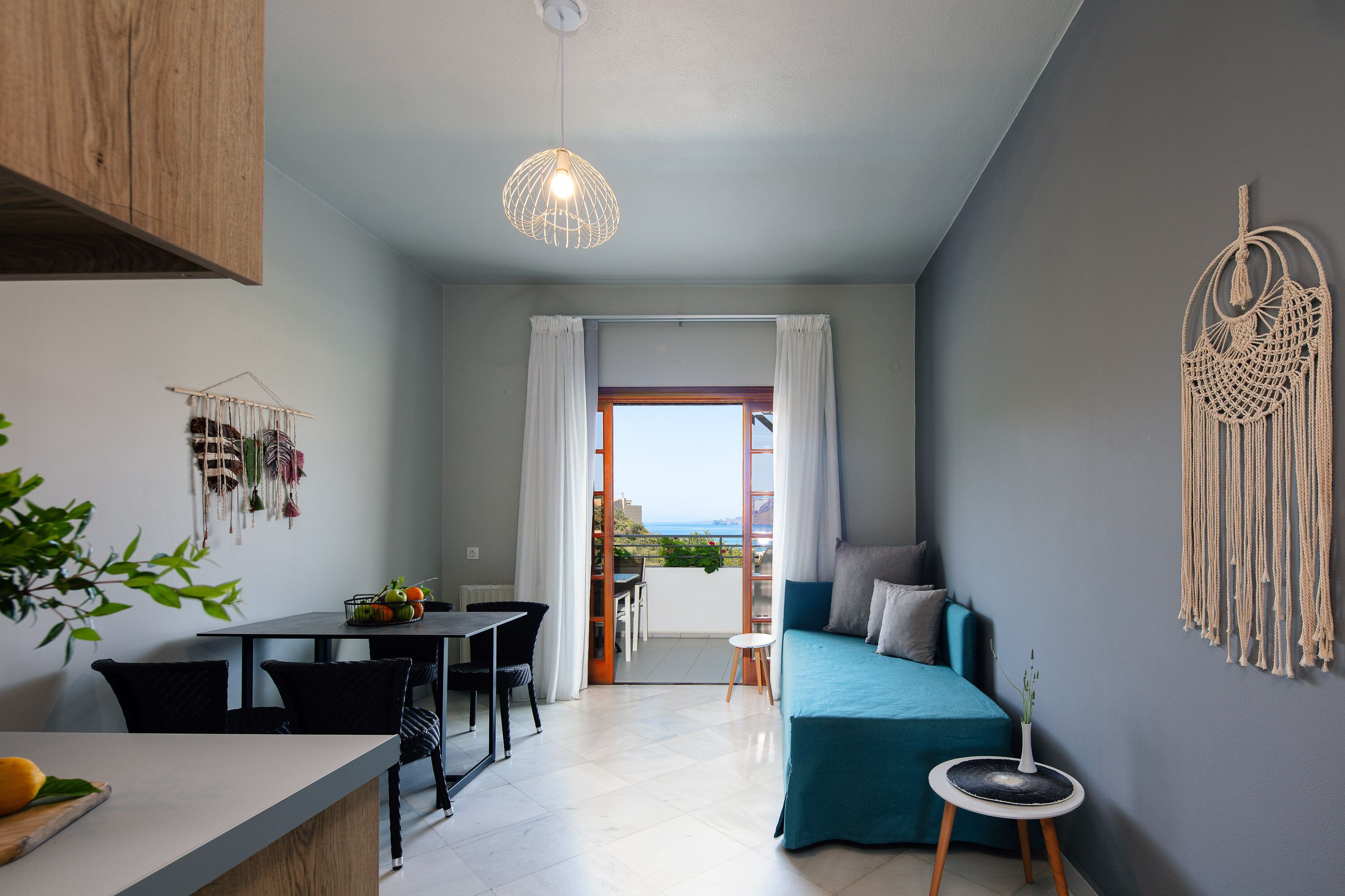 Un espacio habitable moderno y funcional con comedor, sofá y vistas al exterior.