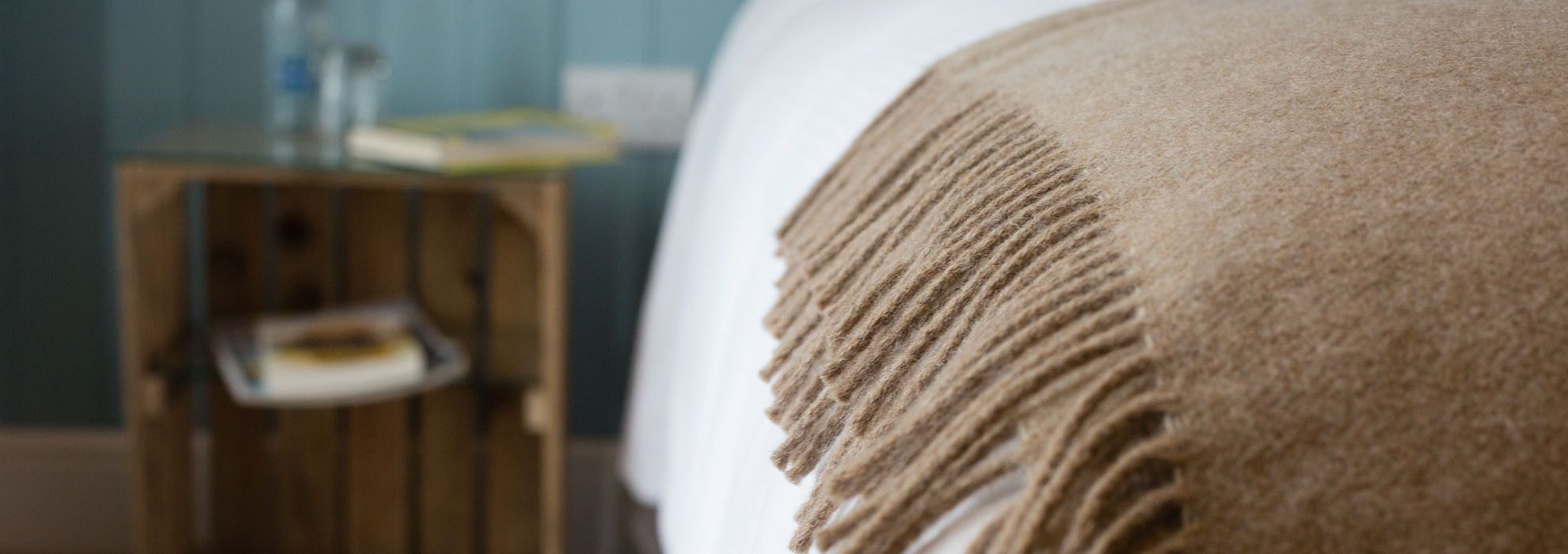 A close-up of a bed with a textured blanket.
