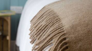 A close-up of a bed with a textured blanket.