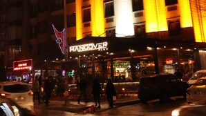 Un edificio de varios pisos con señalización iluminada que dice "HANGOVER HOTEL".