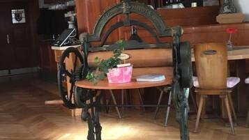 Ein Essbereich mit einem Tisch und Stühlen im Vintage-Stil, einer Holztheke mit Flaschen und einer Chandelier.