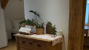 A wooden dresser with drawers, a floral tablecloth, and two potted plants. - Hotel Waldrast B&B (Zwischenwasser)