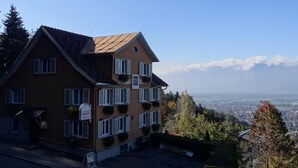 A two-story building with a sign indicating it is a hotel. The building has multiple windows with shutters, and there is a view of a valley and mountains in the background. - Hotel Waldrast B&B (Zwischenwasser)