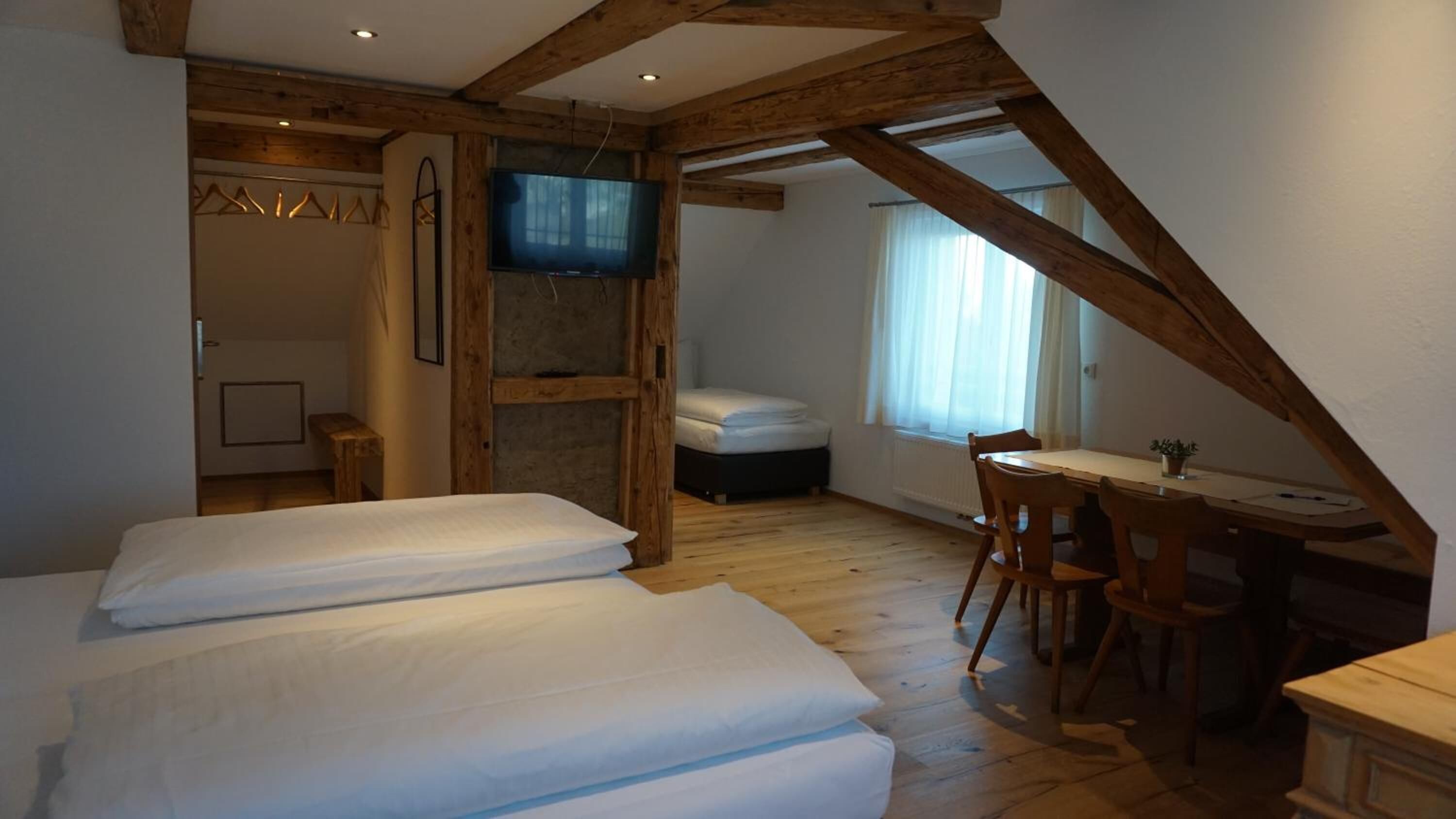 Une chambre avec deux lits, un bureau et une télévision.