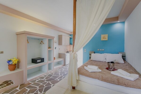 A bedroom with a bed, a bedside table, a nightstand, a wardrobe, a mirror, and a window.