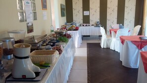 A buffet setup with various food items and serving utensils. - Saint George Hotel & Rooms (Karystos)