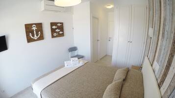 Een slaapkamer met een bed, een stoel en kunst aan de muur.