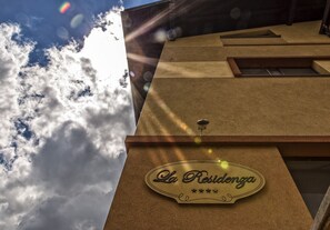 A hotel sign with the name "La Residencia" and a star rating of four stars.