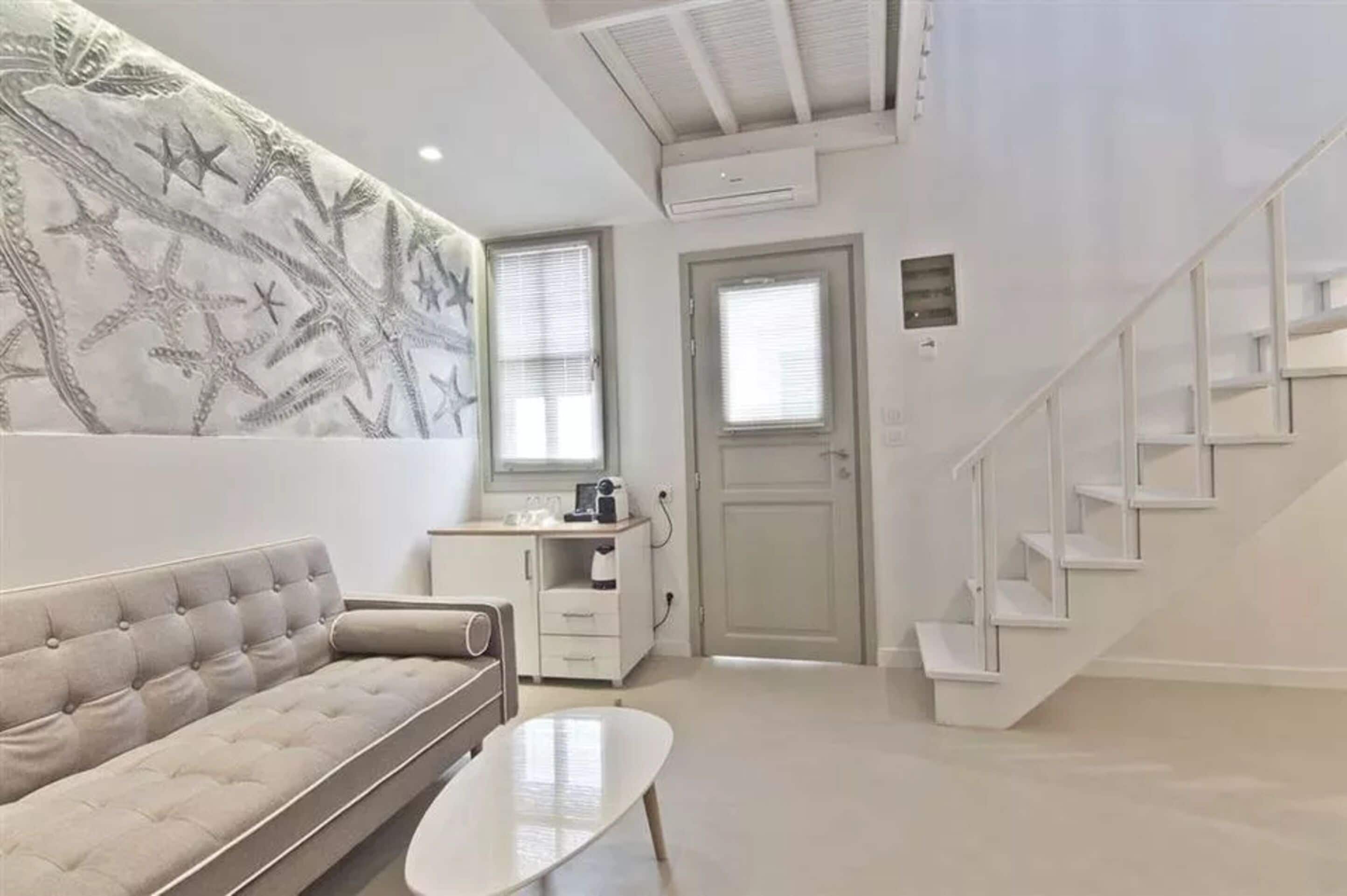 A modern living room with a sofa, a coffee table, and a staircase.