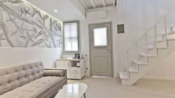 A modern living room with a sofa, a coffee table, and a staircase.