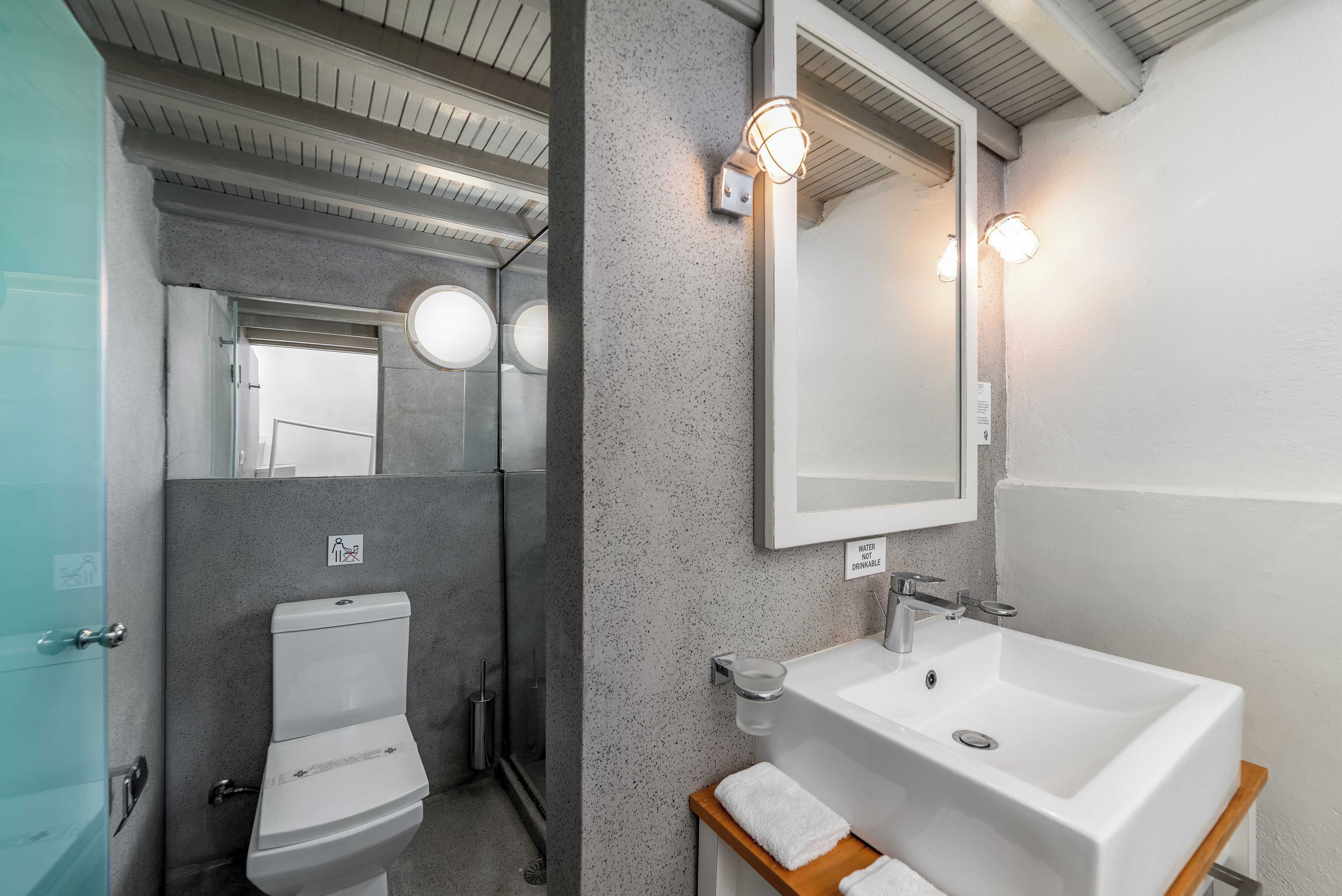 Une salle de bain moderne avec des toilettes, un lavabo et un miroir.