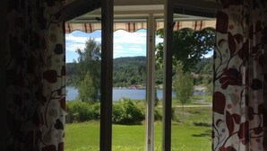 Une chambre avec vue sur un lac et une forêt.