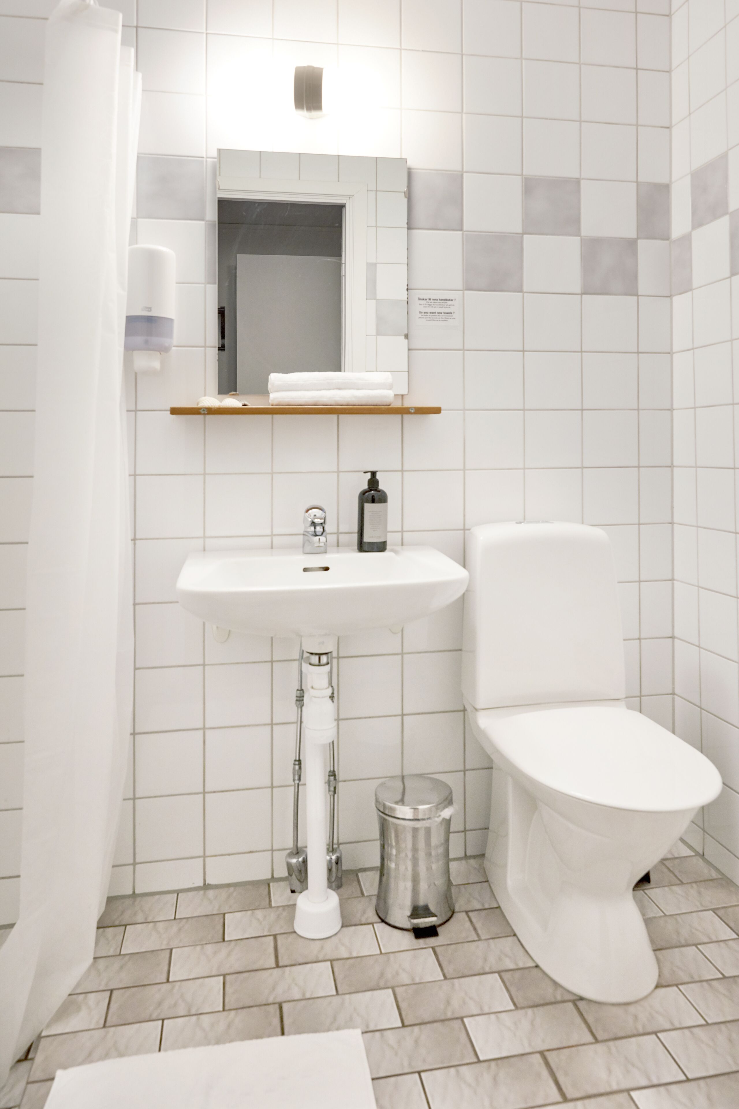 Un baño con lavamanos blanco, inodoro y cortina de ducha.