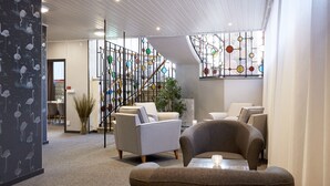 Un intérieur moderne avec un escalier, un coin salon et un mur décoratif.