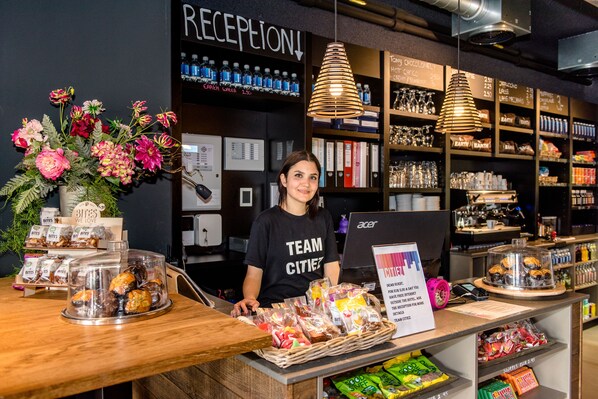 A bakery counter with baked goods and a sign for reception. - Citiez Hotel Amsterdam (Amsterdam)